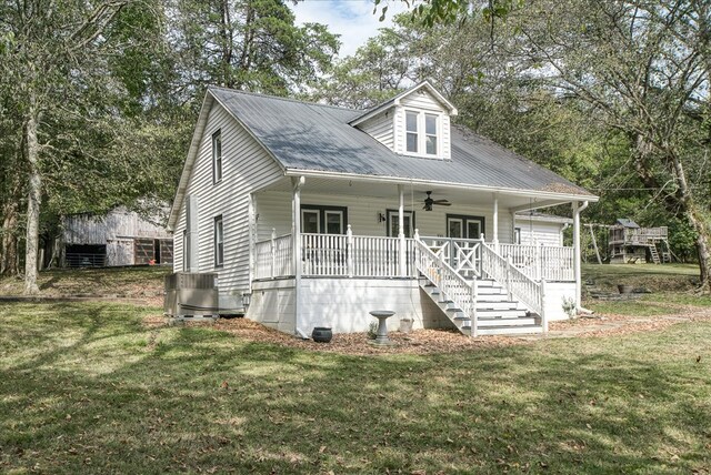 view of front facade with ceiling fan, stairway, metal roof, a porch, and a front yard