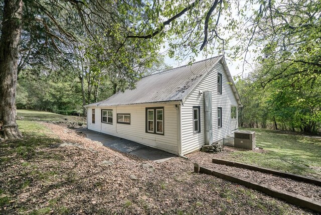 view of home's exterior with central AC unit and metal roof