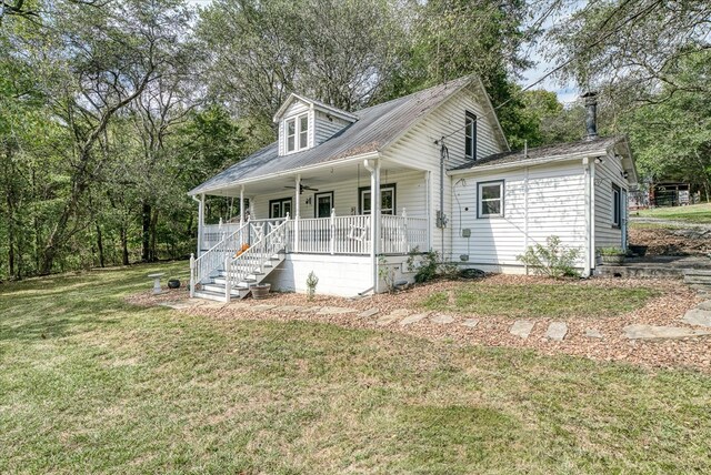 cape cod house featuring stairs, a porch, a front lawn, and a ceiling fan