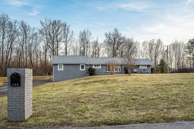 ranch-style home featuring metal roof and a front lawn