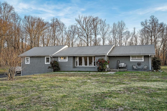 ranch-style home with metal roof and a front yard