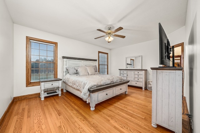 bedroom with light wood finished floors, a ceiling fan, and baseboards