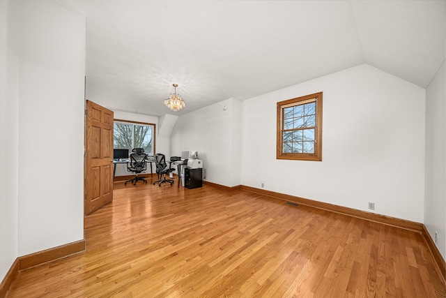 home office featuring lofted ceiling, light wood-type flooring, a chandelier, and baseboards