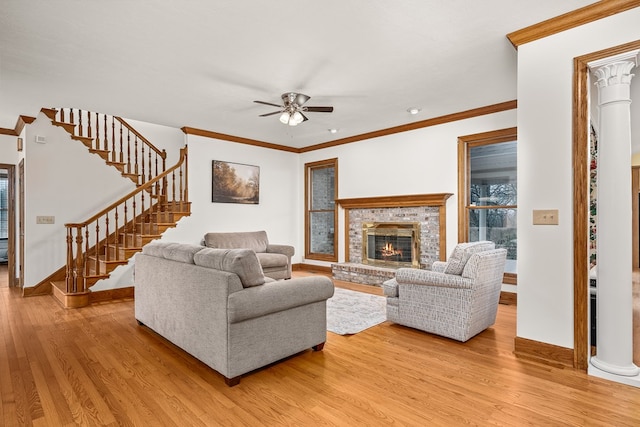 living room with ornamental molding, stairway, wood finished floors, and decorative columns