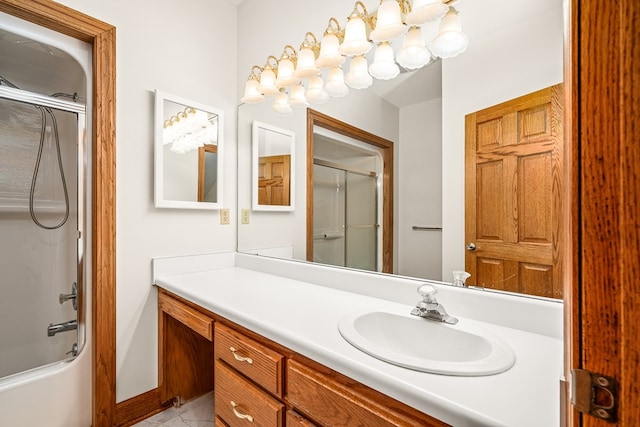 bathroom featuring bath / shower combo with glass door, vanity, and baseboards