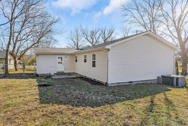 rear view of property featuring crawl space, fence, cooling unit, and a yard