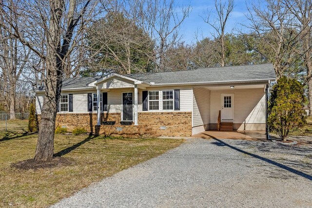 ranch-style home featuring entry steps, driveway, crawl space, a front lawn, and brick siding