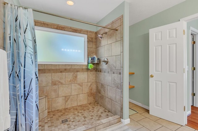 full bath with tile patterned flooring, a shower stall, and baseboards