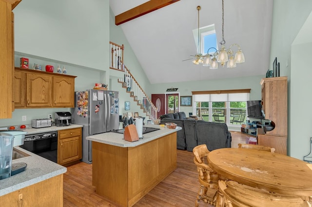 kitchen featuring a notable chandelier, open floor plan, light countertops, hanging light fixtures, and black appliances