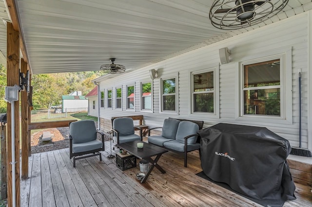 deck featuring a ceiling fan, an outdoor living space, and grilling area