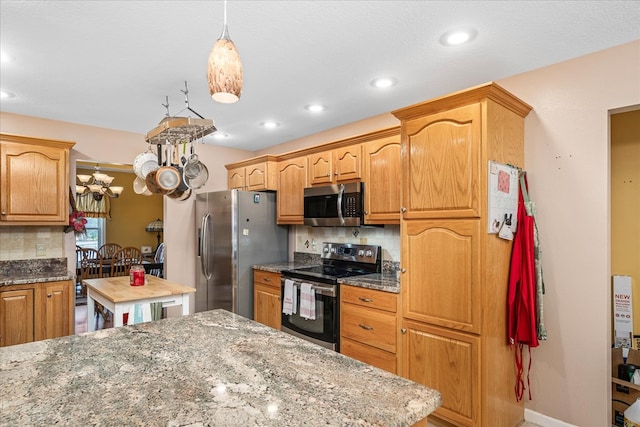 kitchen with butcher block countertops, stainless steel appliances, decorative backsplash, and a center island