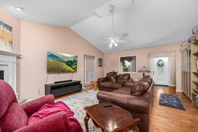 living room with a fireplace, wood finished floors, visible vents, a ceiling fan, and vaulted ceiling