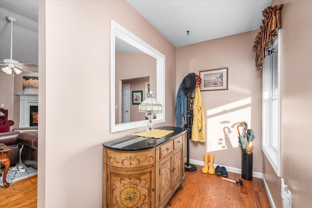 corridor with light wood-style floors and baseboards