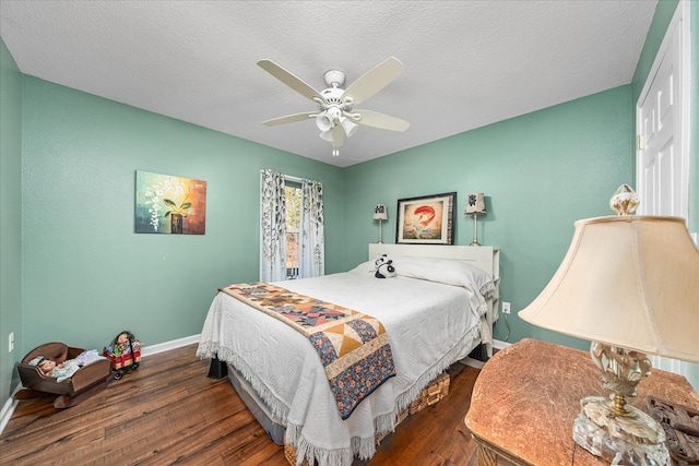 bedroom featuring dark wood-style floors, a textured ceiling, baseboards, and a ceiling fan