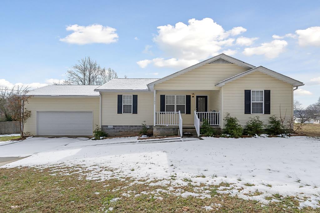 ranch-style home with an attached garage and covered porch