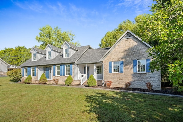 cape cod-style house featuring brick siding, a front lawn, and a shingled roof