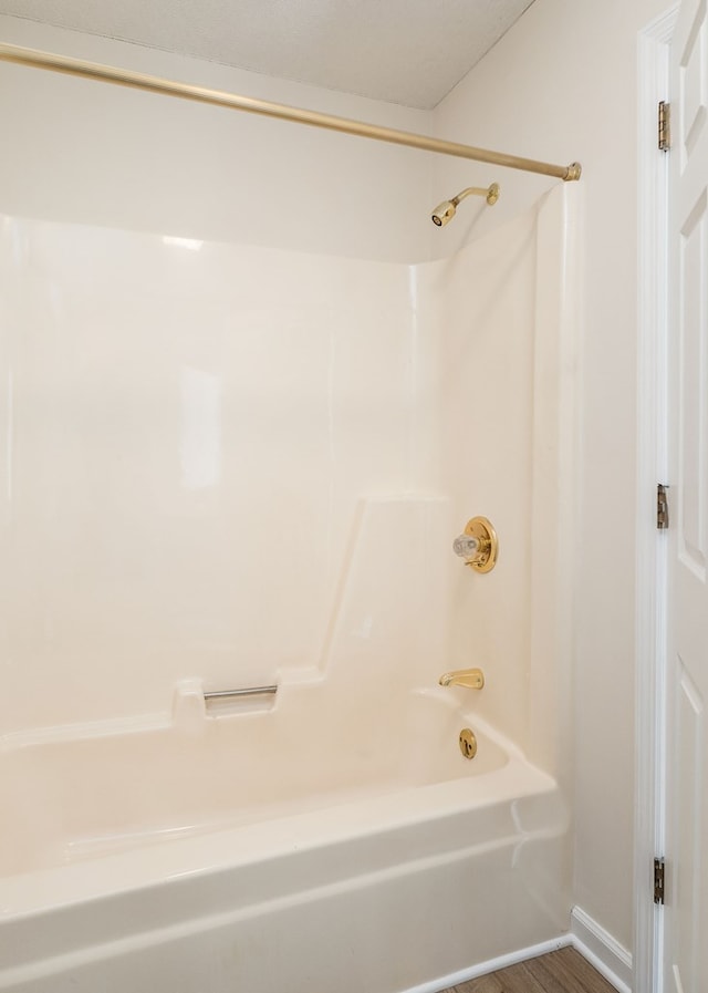 bathroom with bathing tub / shower combination and wood finished floors