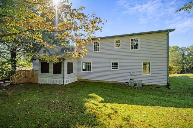 back of house featuring a yard and central AC