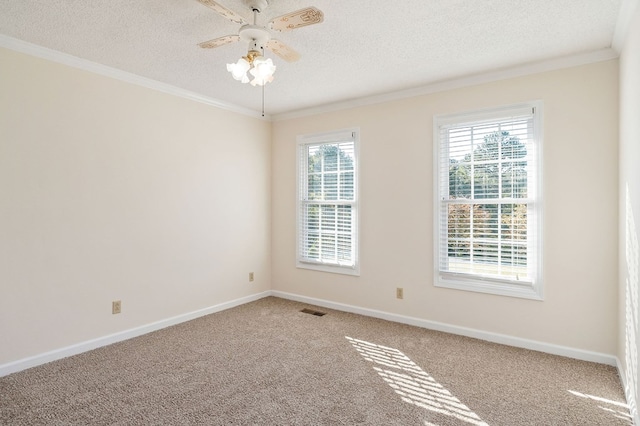 empty room featuring carpet, visible vents, ornamental molding, a textured ceiling, and baseboards