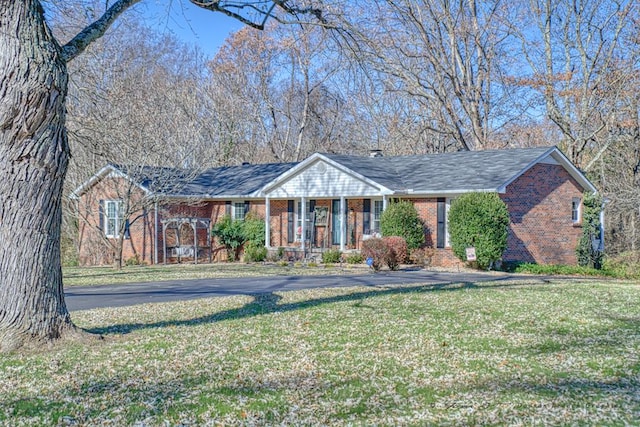 single story home featuring brick siding and a front lawn