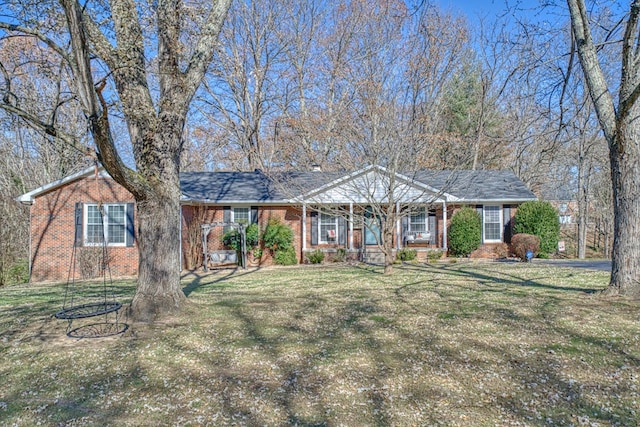 ranch-style home featuring a porch, a front lawn, and brick siding