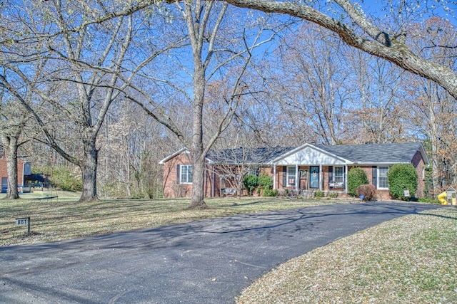 single story home featuring driveway, a front lawn, a porch, and brick siding