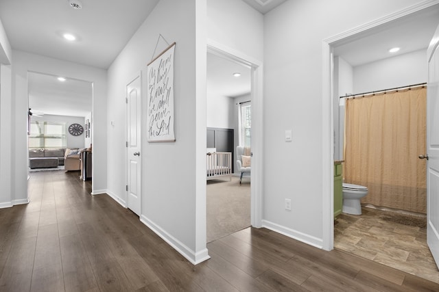 hallway with dark wood-type flooring, recessed lighting, and baseboards