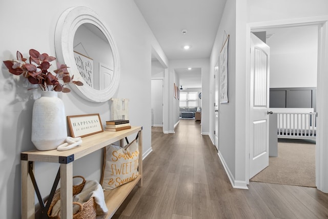 corridor with wood finished floors and baseboards