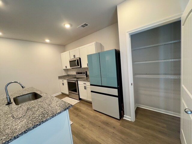 336 Oliver Way, Baxter, TN 38544 - kitchen featuring appliances with stainless steel finishes, a sink, dark stone counters, dark wood finished floors, and recessed lighting