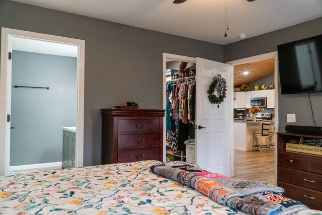 bedroom with light wood-type flooring, a walk in closet, and a closet