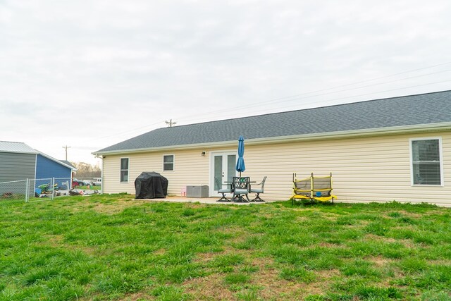 rear view of property featuring a yard, cooling unit, fence, and a patio