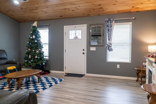 foyer entrance featuring visible vents, vaulted ceiling, light wood-type flooring, wooden ceiling, and baseboards