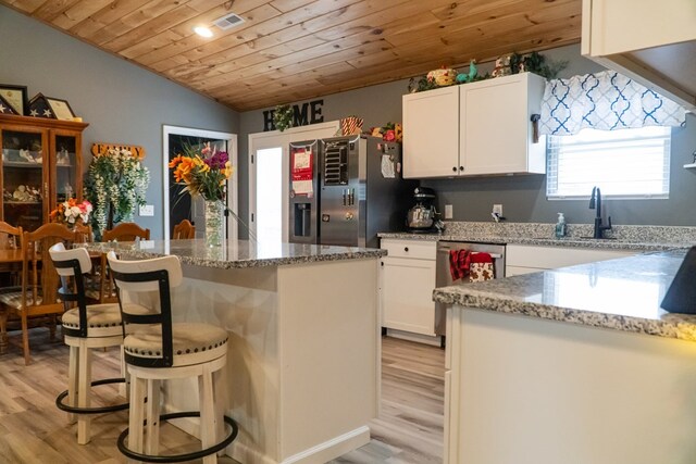 kitchen with wooden ceiling, light stone countertops, white cabinetry, and stainless steel appliances