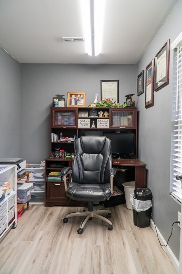 home office featuring light wood-style floors, baseboards, and visible vents