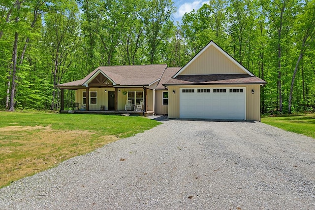 98 Paso Fino Trl, Jamestown, TN 38556 - view of front of home with gravel driveway, a porch, a front lawn, a garage, and a shingled roof