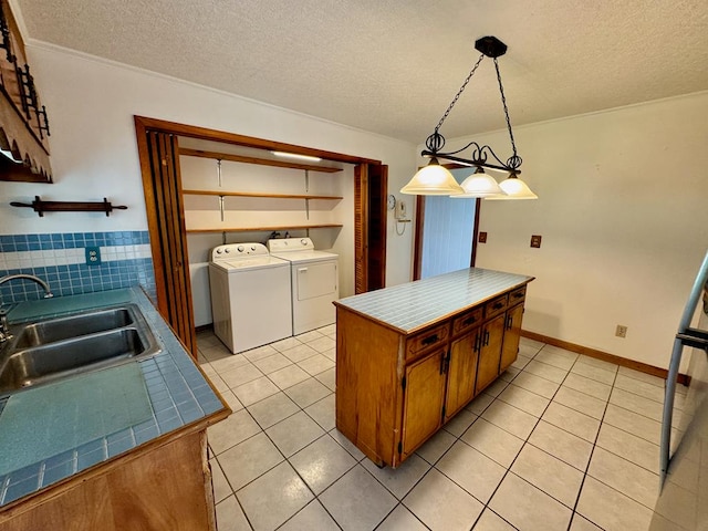 1039 Old Martha Washington Rd, Clarkrange, TN 38553 - kitchen with light tile patterned flooring, washer and clothes dryer, a textured ceiling, brown cabinets, and tile countertops
