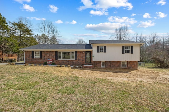 split level home with a front lawn, fence, and brick siding