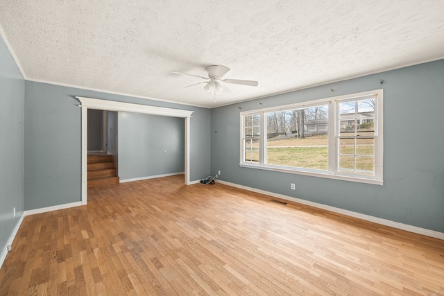 unfurnished room with a ceiling fan, baseboards, visible vents, hardwood / wood-style flooring, and crown molding