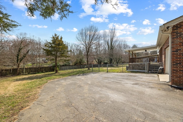 view of yard with aphalt driveway, a garage, a patio, and a fenced backyard