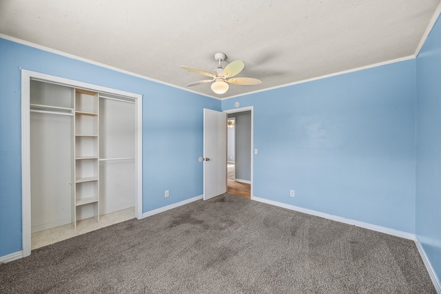 unfurnished bedroom featuring a ceiling fan, baseboards, carpet floors, a closet, and crown molding