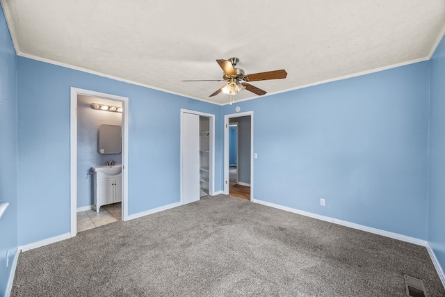 unfurnished bedroom featuring carpet flooring, visible vents, and ornamental molding