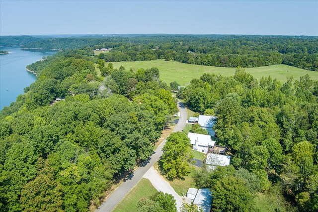 birds eye view of property with a wooded view and a water view