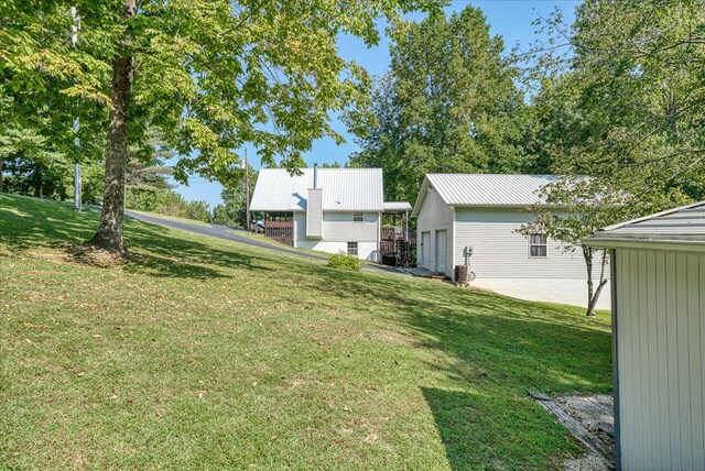 view of yard featuring a detached garage and an outbuilding