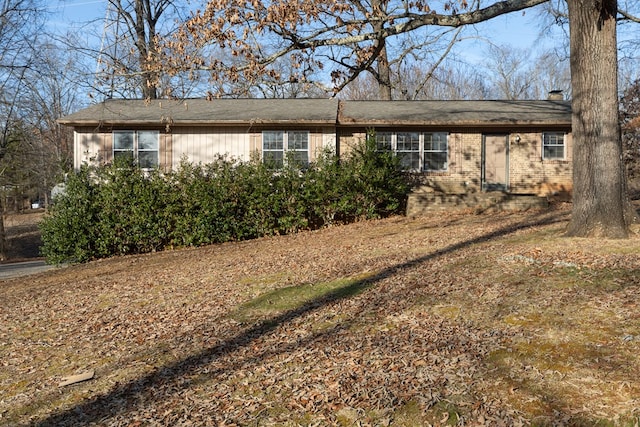 ranch-style home with brick siding and a chimney