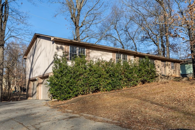 view of front of property featuring brick siding, an attached garage, and driveway