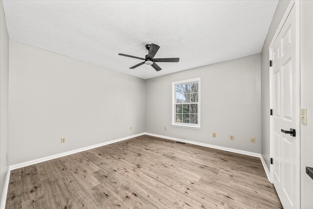 unfurnished bedroom with light wood-type flooring, ceiling fan, a textured ceiling, and baseboards