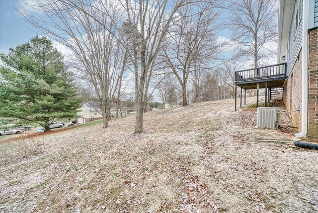 view of yard featuring a wooden deck and central air condition unit