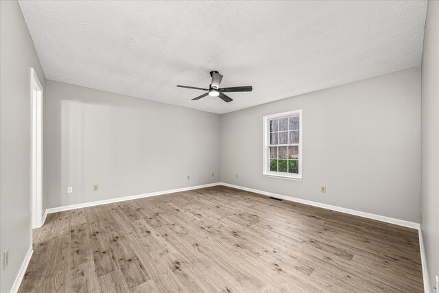 spare room with visible vents, baseboards, ceiling fan, a textured ceiling, and light wood-type flooring