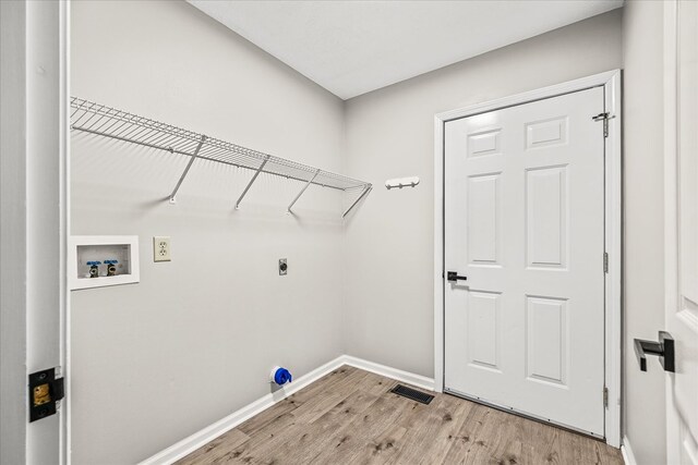 laundry room featuring hookup for a washing machine, laundry area, visible vents, baseboards, and light wood finished floors