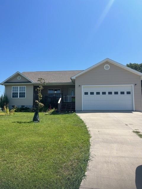 single story home featuring driveway, crawl space, an attached garage, a front lawn, and a porch